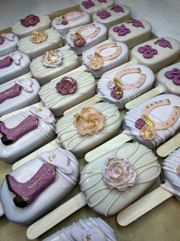 Western-themed cakesicles with boots and horseshoes